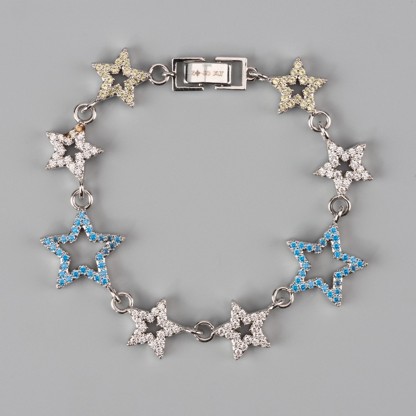 Star-shaped bracelet and collar with blue and clear gemstones on a gray background